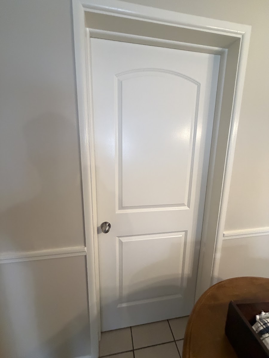 Newly installed white interior door with painted trim