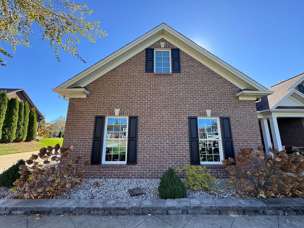 Brick house exterior with painted black shutters